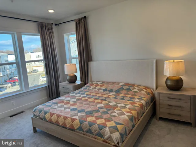 a bedroom with a bed and large windows