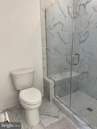 a white toilet next to a shower
