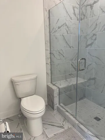 a white toilet next to a shower