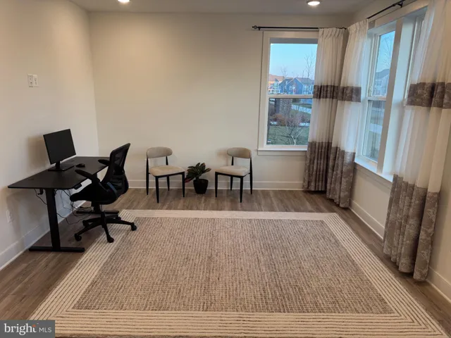 a view of a workspace with furniture and a window