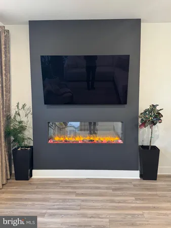a view of a living room with a fireplace and wooden floor