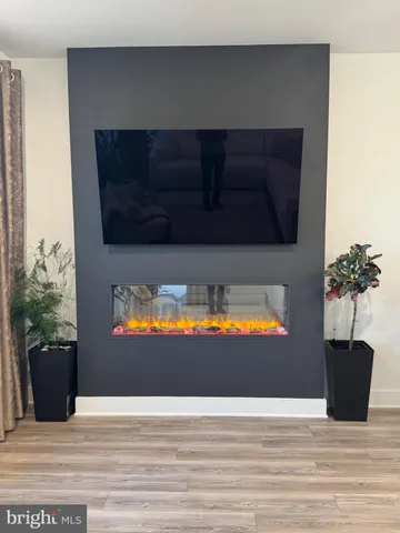 a view of a living room with a fireplace and wooden floor