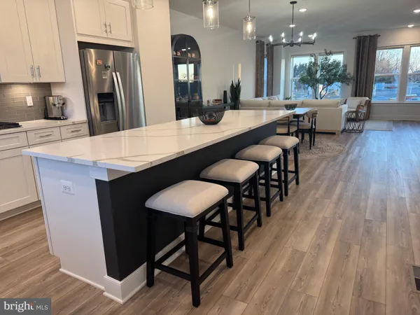 an open kitchen with granite countertop a counter space dining table and stainless steel appliances