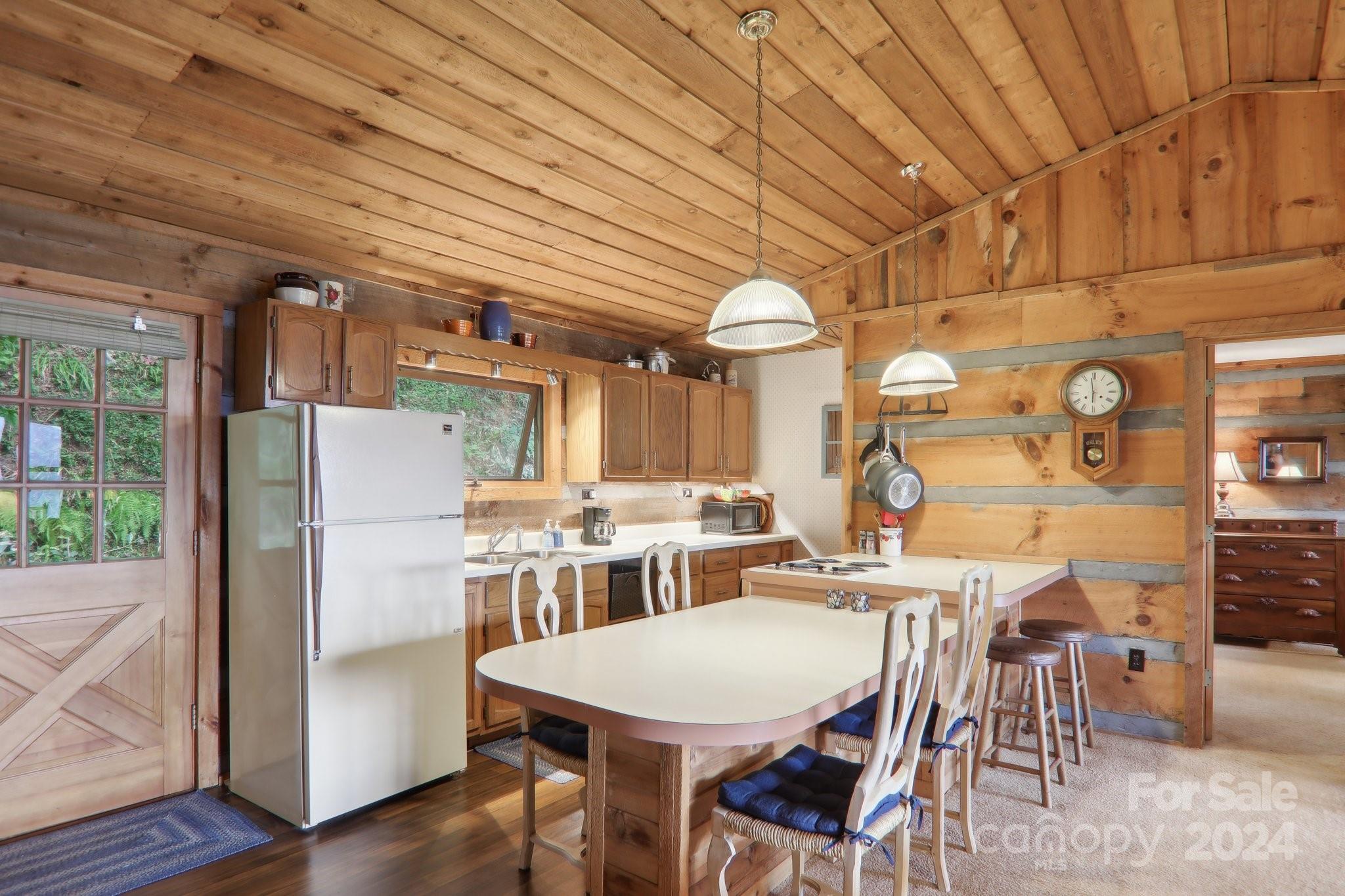 1685 Setzercove Road Maggie Valley, NC 28751 - Photo 16 of 42 a dining room with kitchen island a table and chairs