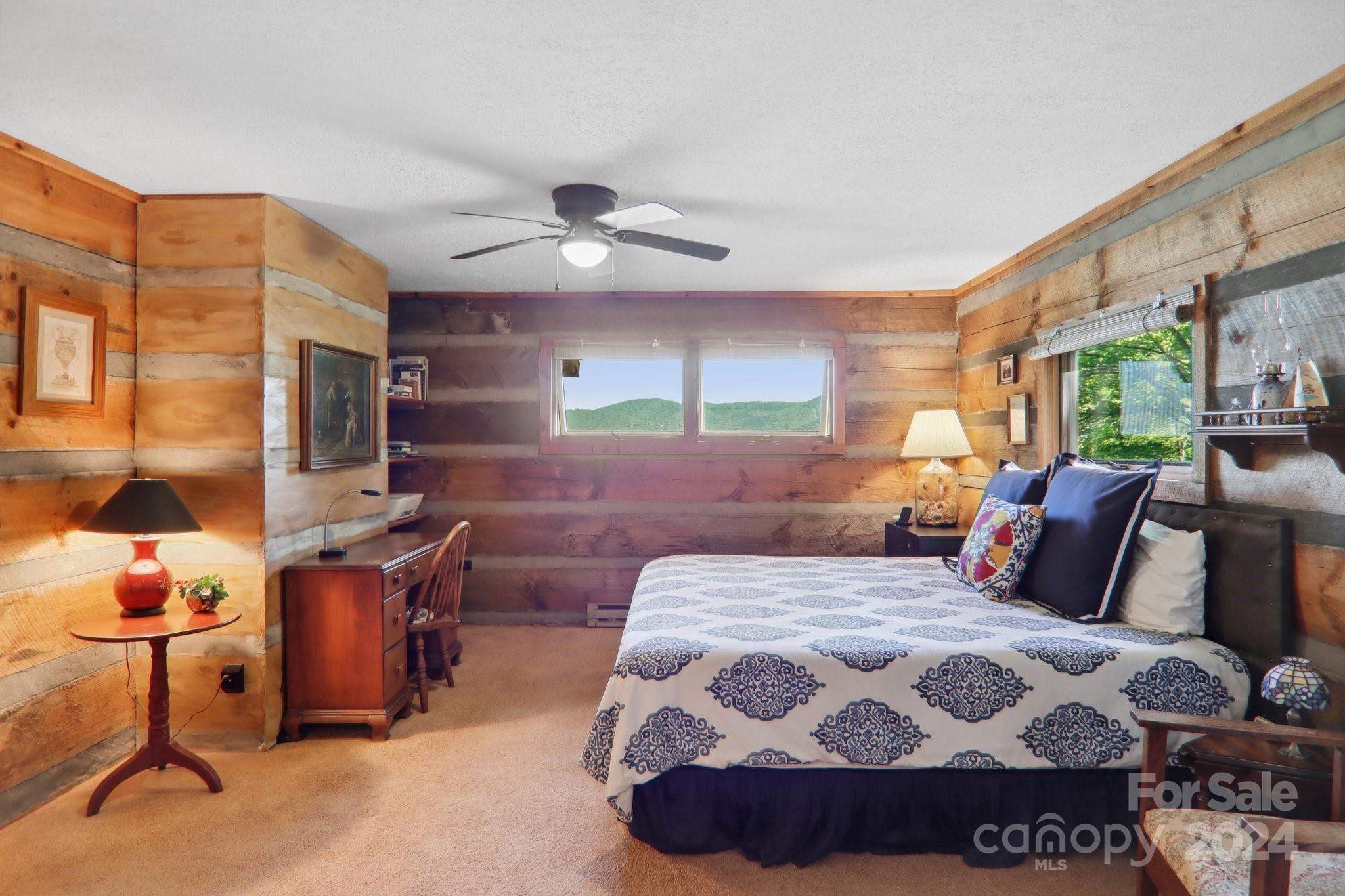 1685 Setzercove Road Maggie Valley, NC 28751 - Photo 18 of 42 a bedroom with a large bed and a chandelier