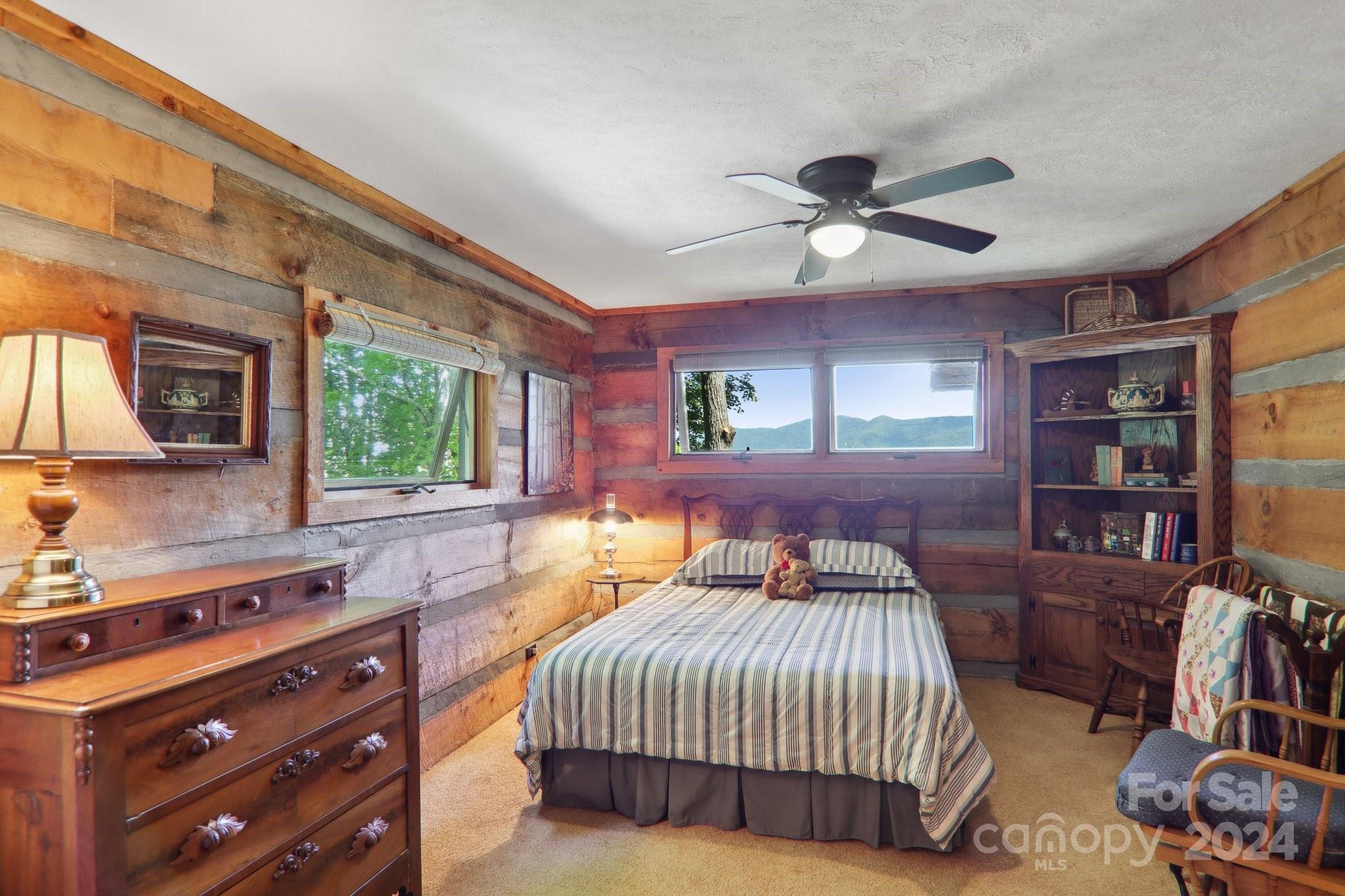 1685 Setzercove Road Maggie Valley, NC 28751 - Photo 21 of 42 a bedroom with a bed a flat screen tv and a large window with the outer view