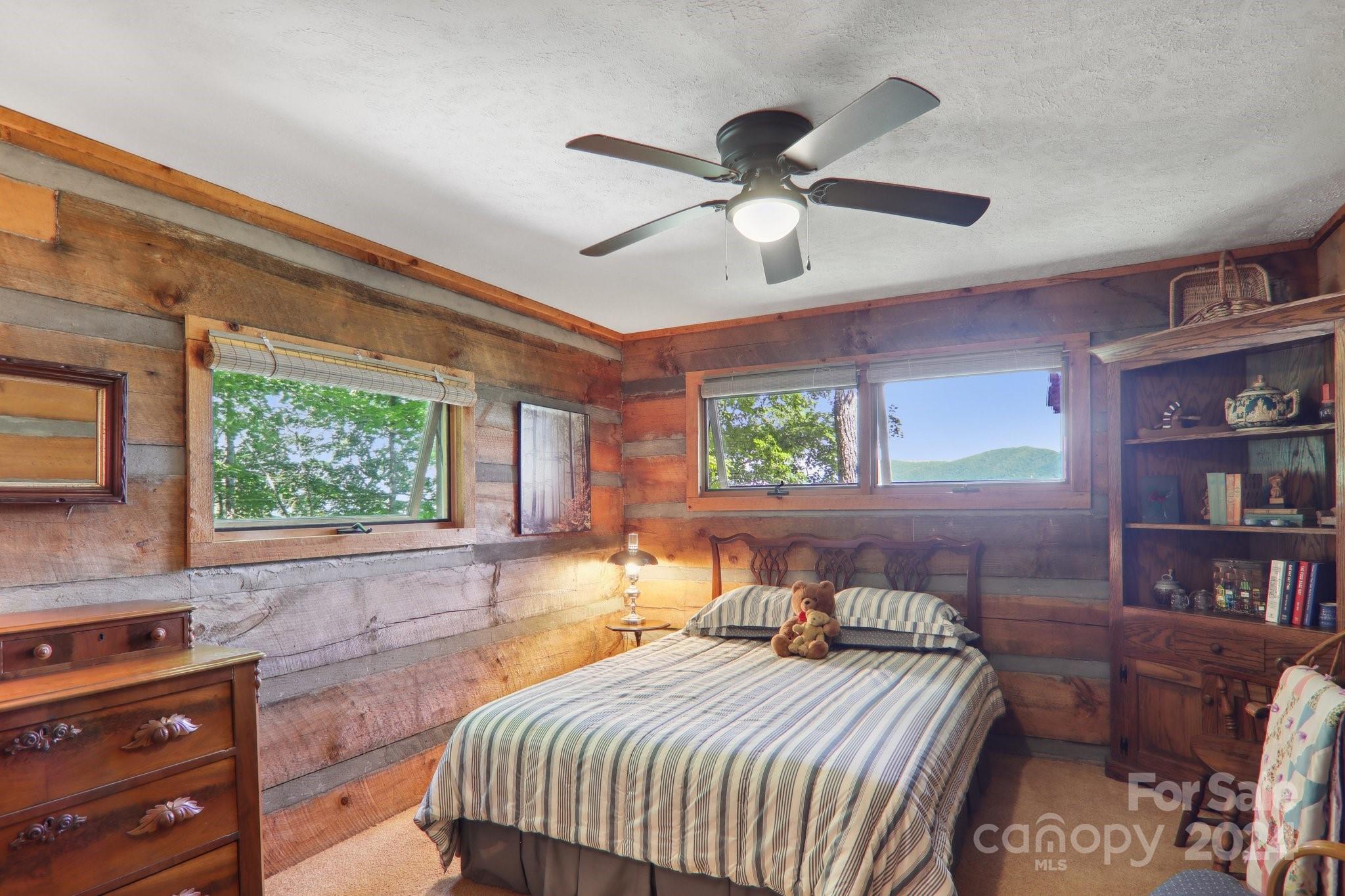 1685 Setzercove Road Maggie Valley, NC 28751 - Photo 22 of 42 a bedroom with a bed and a chandelier