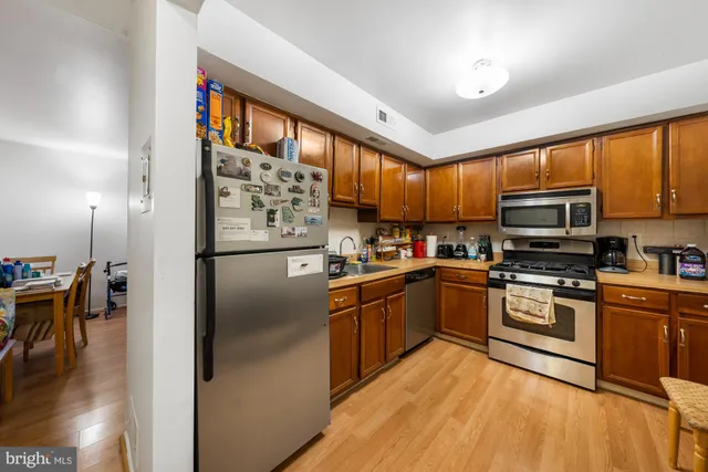 a kitchen with stainless steel appliances granite countertop a refrigerator a stove top oven a sink and dishwasher