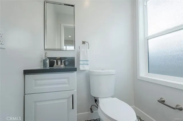 a bathroom with a toilet a sink a vanity and mirror