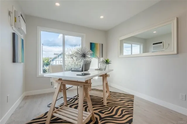 a view of a workspace with furniture and a window