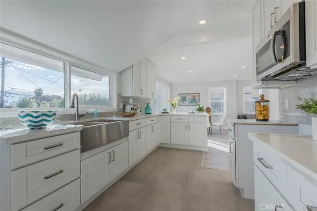 a dining hall with stainless steel appliances kitchen island granite countertop a table and chairs in it