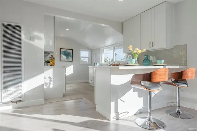 a kitchen with stainless steel appliances a white table chairs and white cabinets