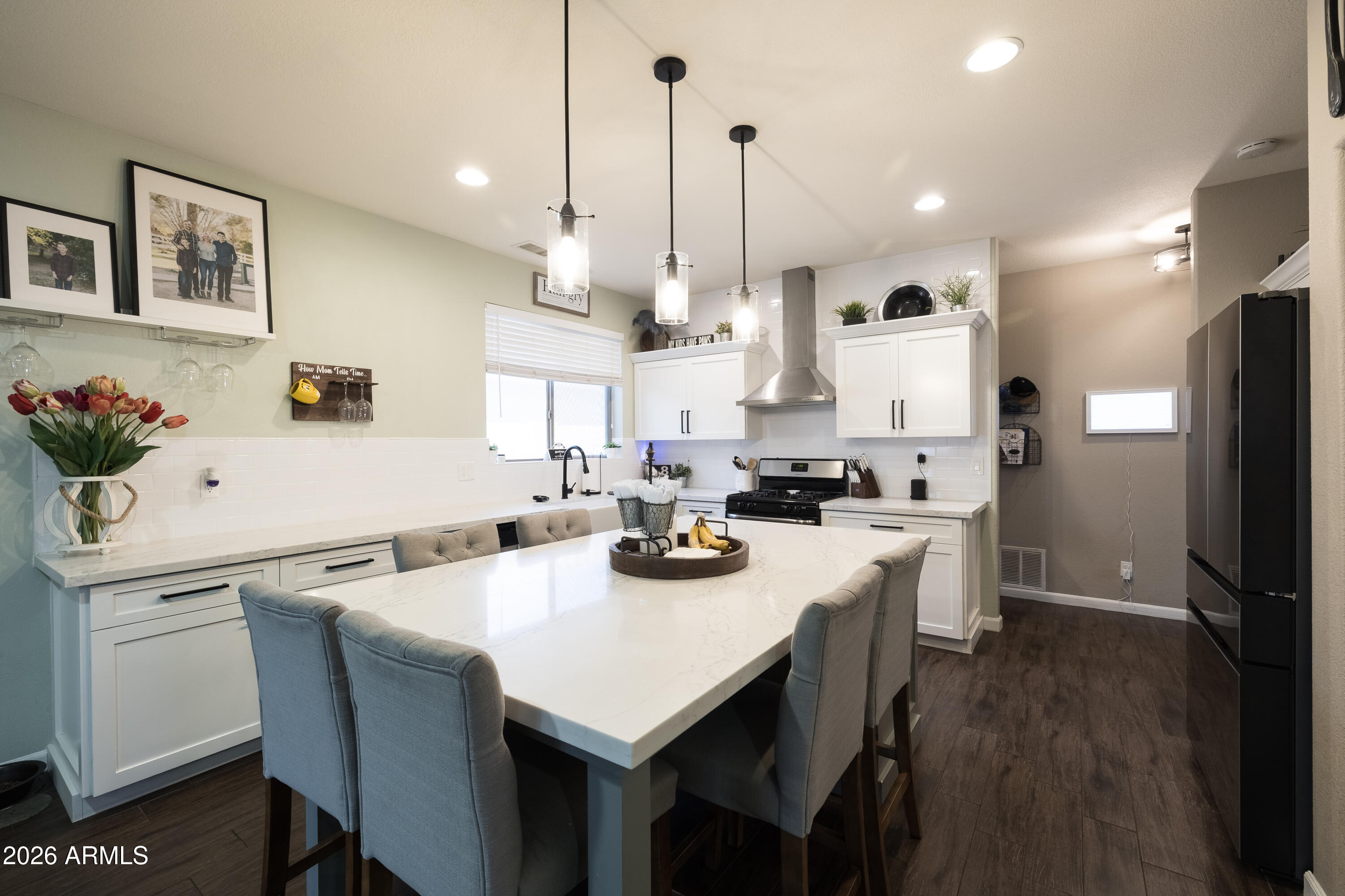 6407 West Saddlehorn Road Phoenix, AZ 85083 - Photo 22 of 41 a kitchen with a sink a stove a refrigerator and white cabinets with wooden floor