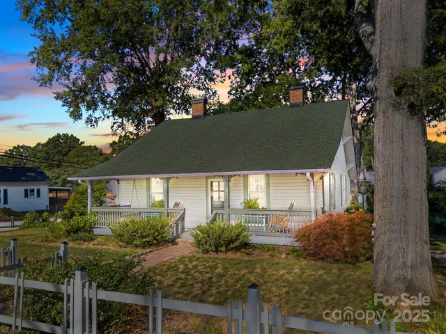 a view of a house with a tree in the yard
