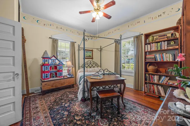 a living room with furniture a bookshelf and a window