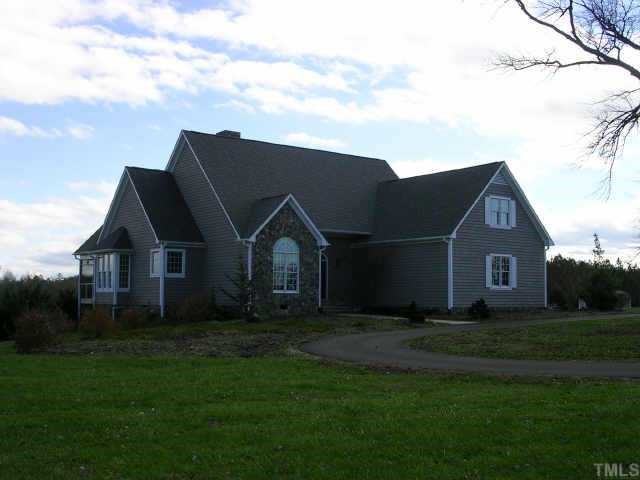 7208 Wiley Mangum Road Bahama, NC 27503 - Photo 1 of 1 a house that is sitting in the grass with large trees