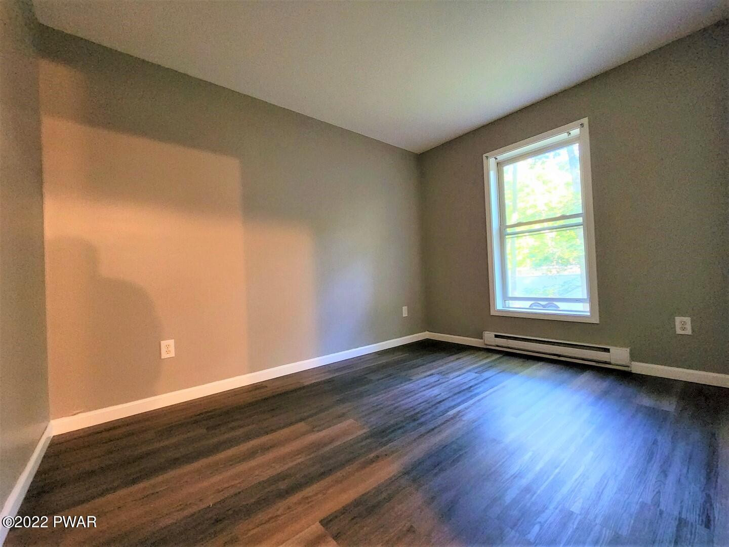 113 Butternut Road Milford, PA 18337 - Photo 9 of 15 a view of an empty room with wooden floor and a window