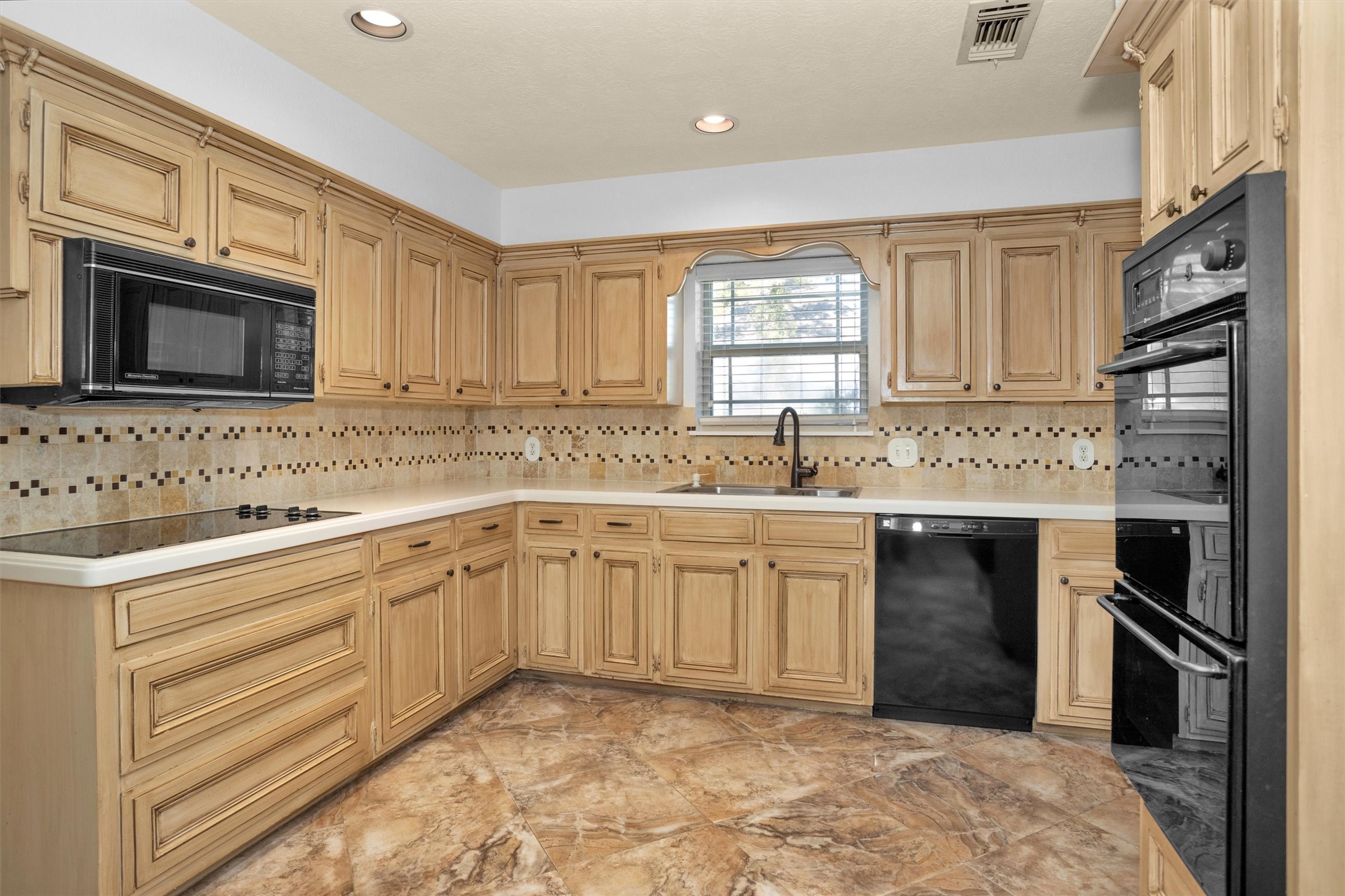 6903 Farnaby Court Spring, TX 77379 - Photo 15 of 49 a kitchen with granite countertop a sink stainless steel appliances and cabinets