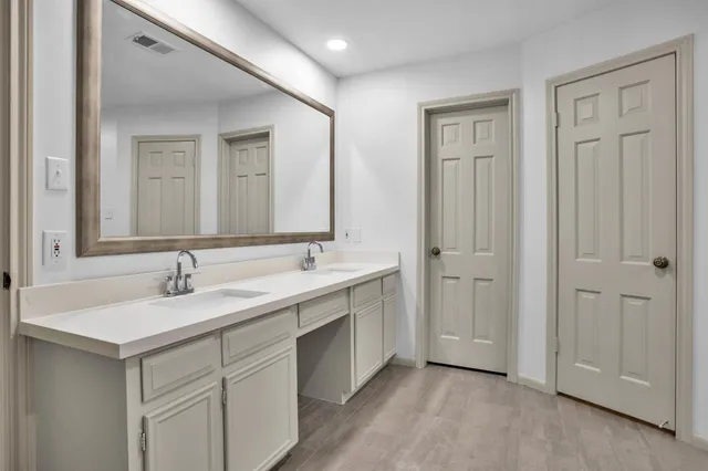 a bathroom with a double vanity sink and mirror