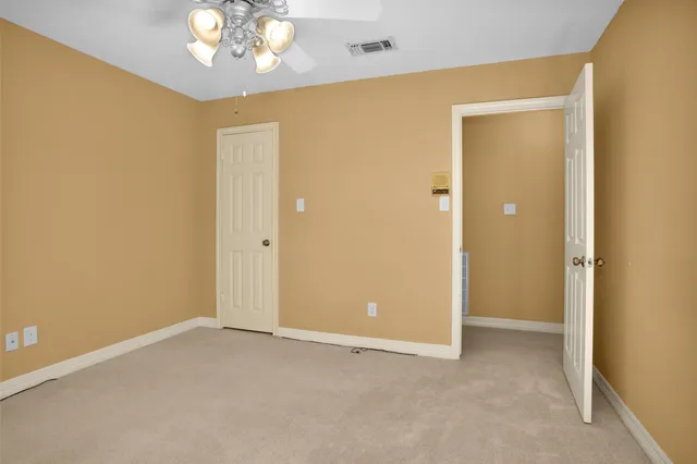 a view of an empty room with a chandelier fan