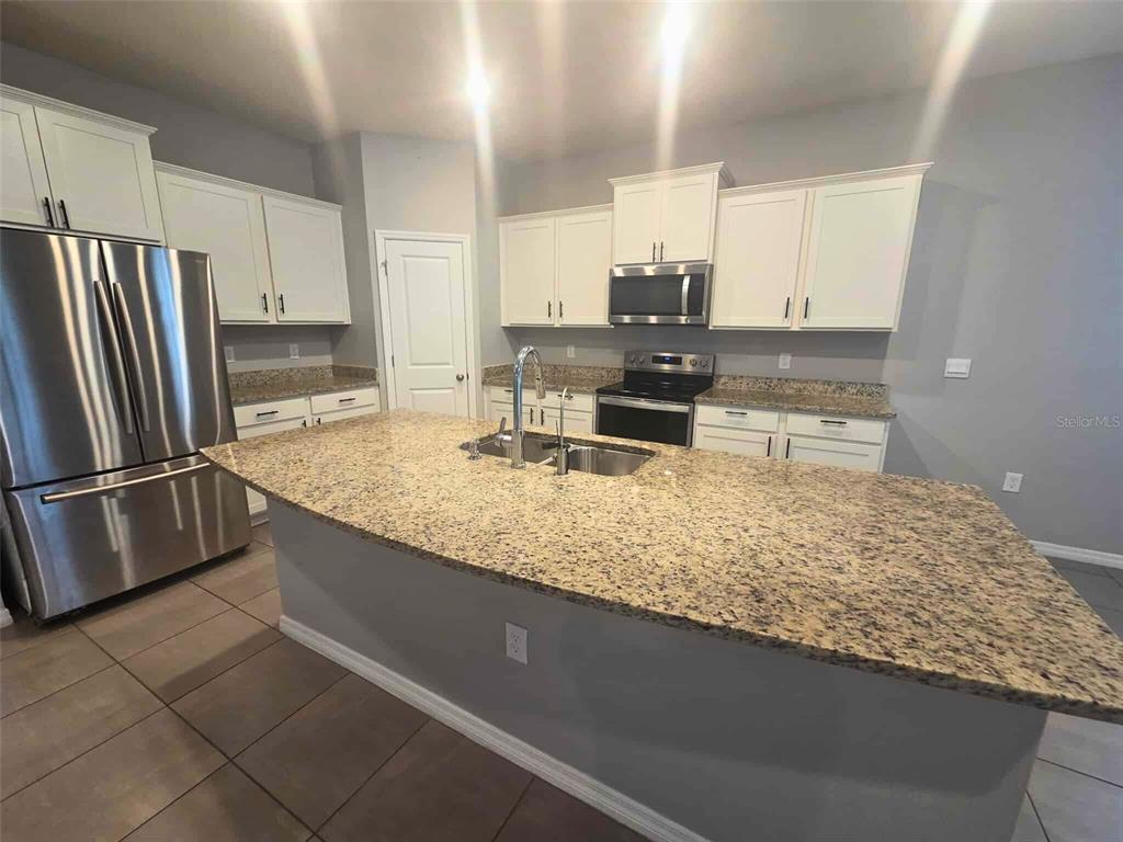3927 Lively Coral Place Bradenton, FL 34208 - Photo 16 of 44 a kitchen with stainless steel appliances granite countertop a sink refrigerator and microwave