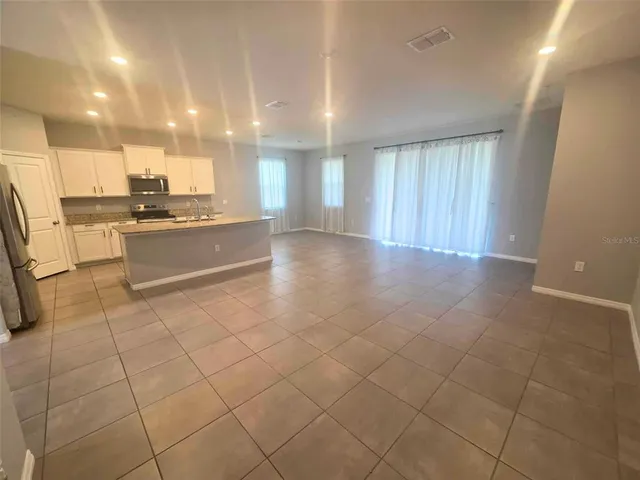 a large white kitchen with a sink and cabinets