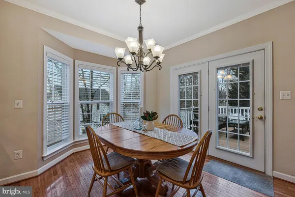 a dining room with furniture a chandelier and wooden floor