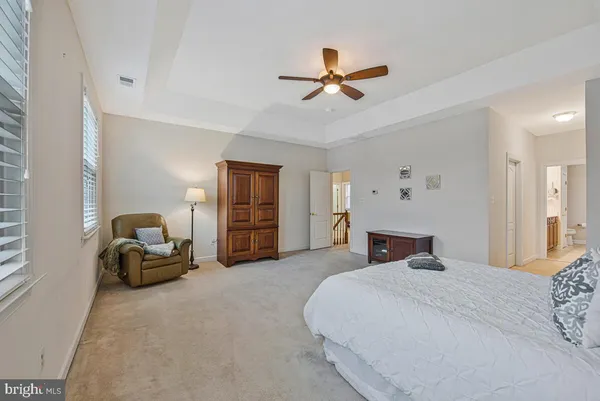 a bedroom with a balcony and ceiling fan