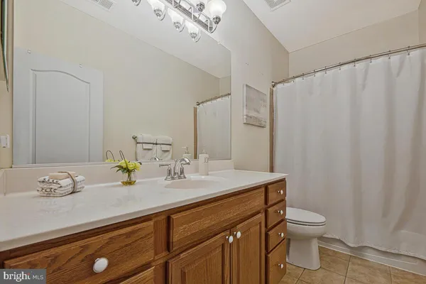 a bathroom with a granite countertop sink a toilet and a mirror