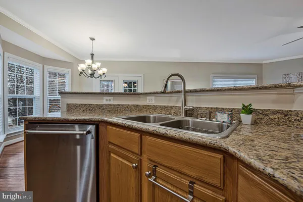 a kitchen with granite countertop a sink stainless steel appliances and cabinets
