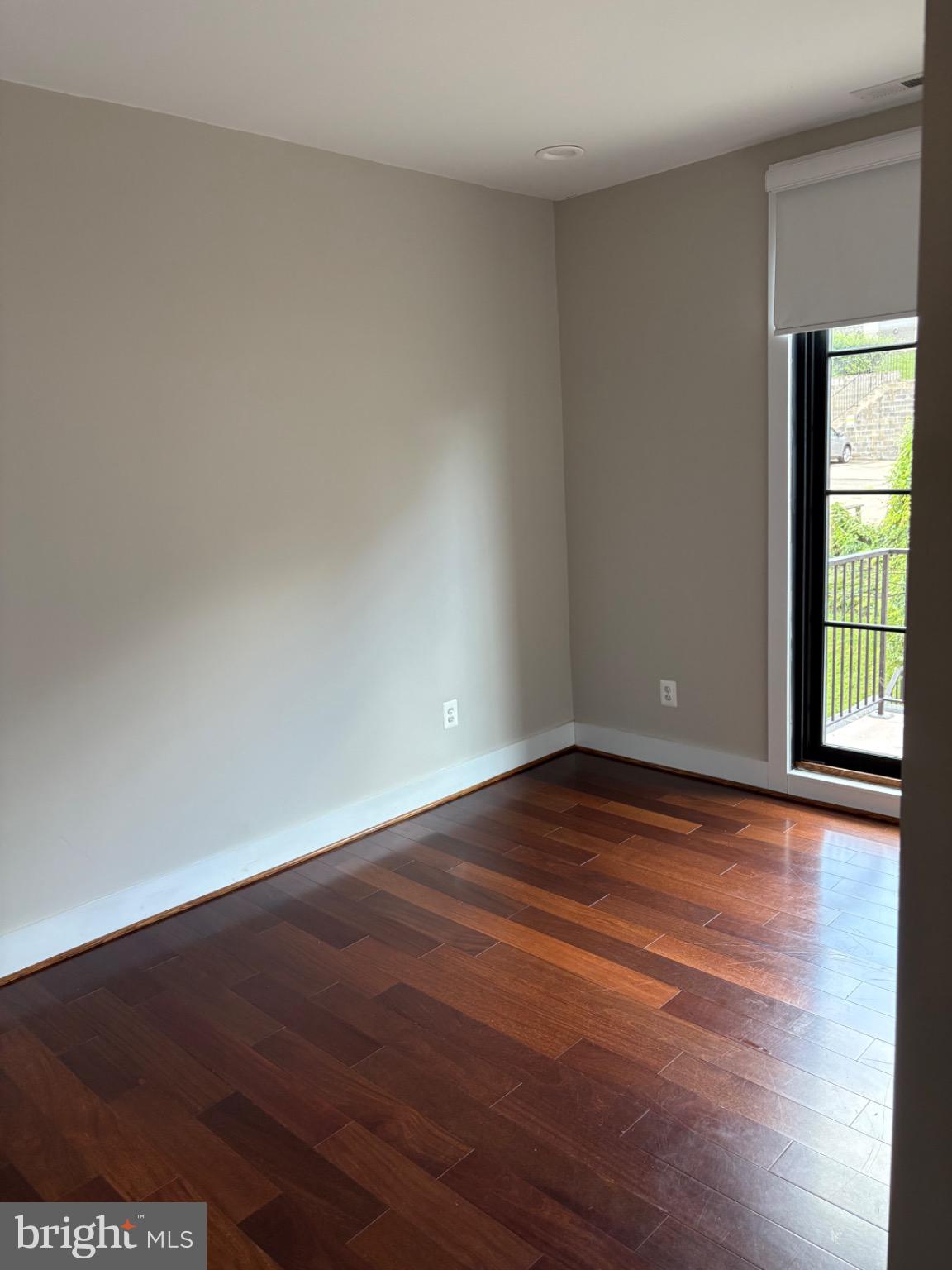 4004 Edmunds Street Northwest, Unit 7 Washington, DC 20007 - Photo 7 of 12 a view of an empty room with wooden floor and a window