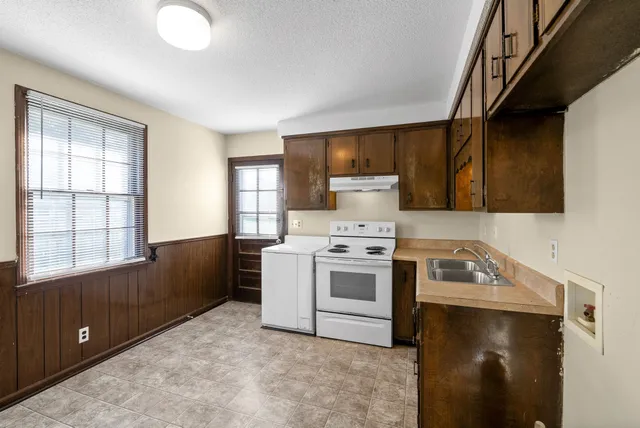 a kitchen with a stove a sink and a microwave