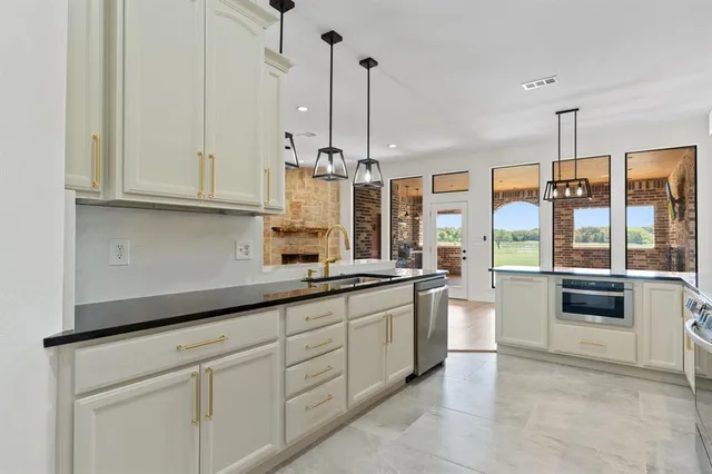 a kitchen with stainless steel appliances granite countertop a stove a sink and a white cabinets