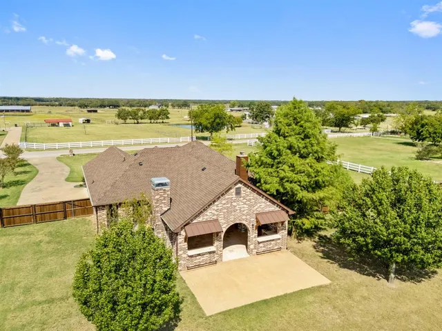 an aerial view of ocean and residential houses with outdoor space