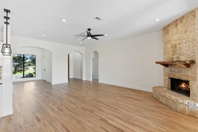 a view of a livingroom with wooden floor and a fireplace