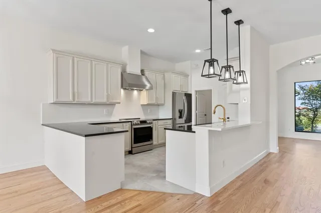 a kitchen with stainless steel appliances kitchen island a sink stove and cabinets