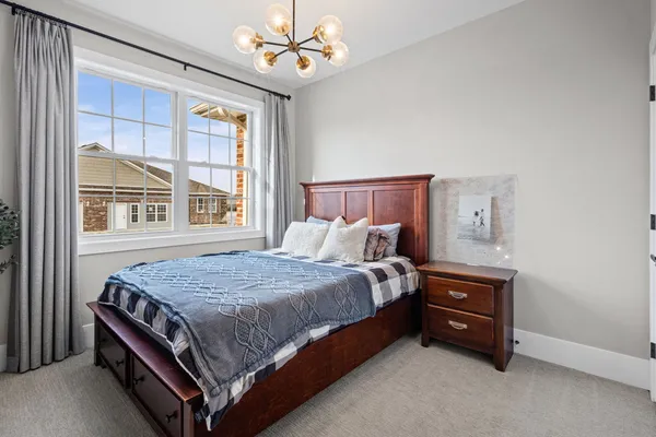 a bed sitting in a bedroom next to a window