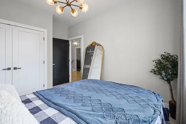a bedroom with a bed and a chandelier