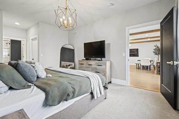 a bedroom with a bed and a chandelier