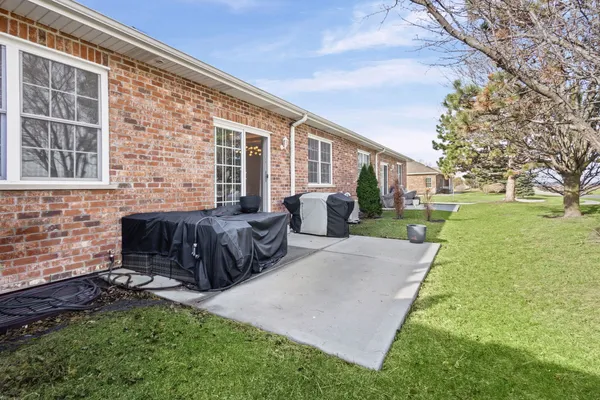 a view of a house with backyard and sitting area