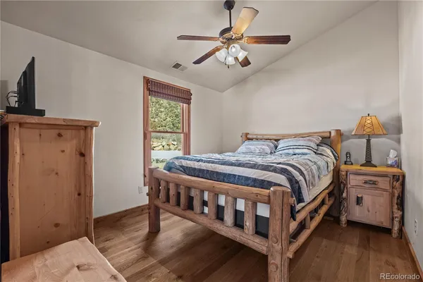a bedroom with a bed a flat screen tv and a chandelier