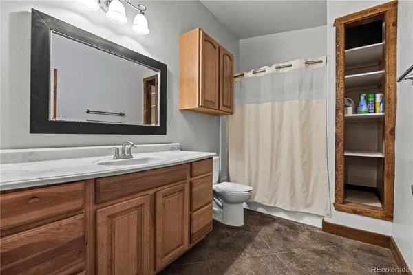 a bathroom with a toilet sink double vanity and shower