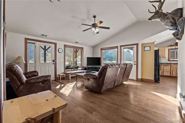 a living room with furniture a ceiling fan and a window
