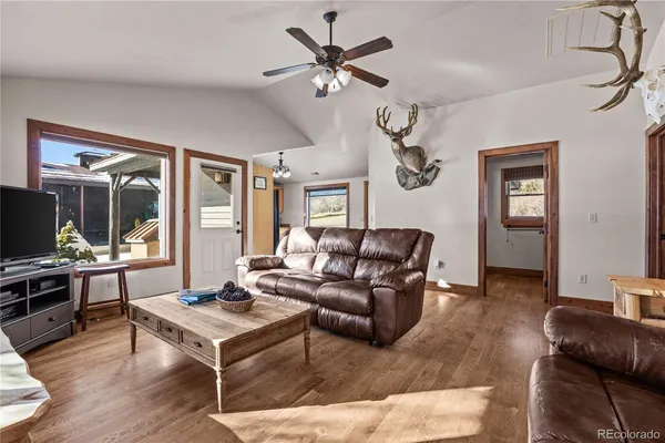 a living room with furniture ceiling fan and a wooden floor