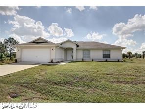 101 West 12th Street Lehigh Acres, FL 33972 - Photo 1 of 7 a view of a house with a yard and garage