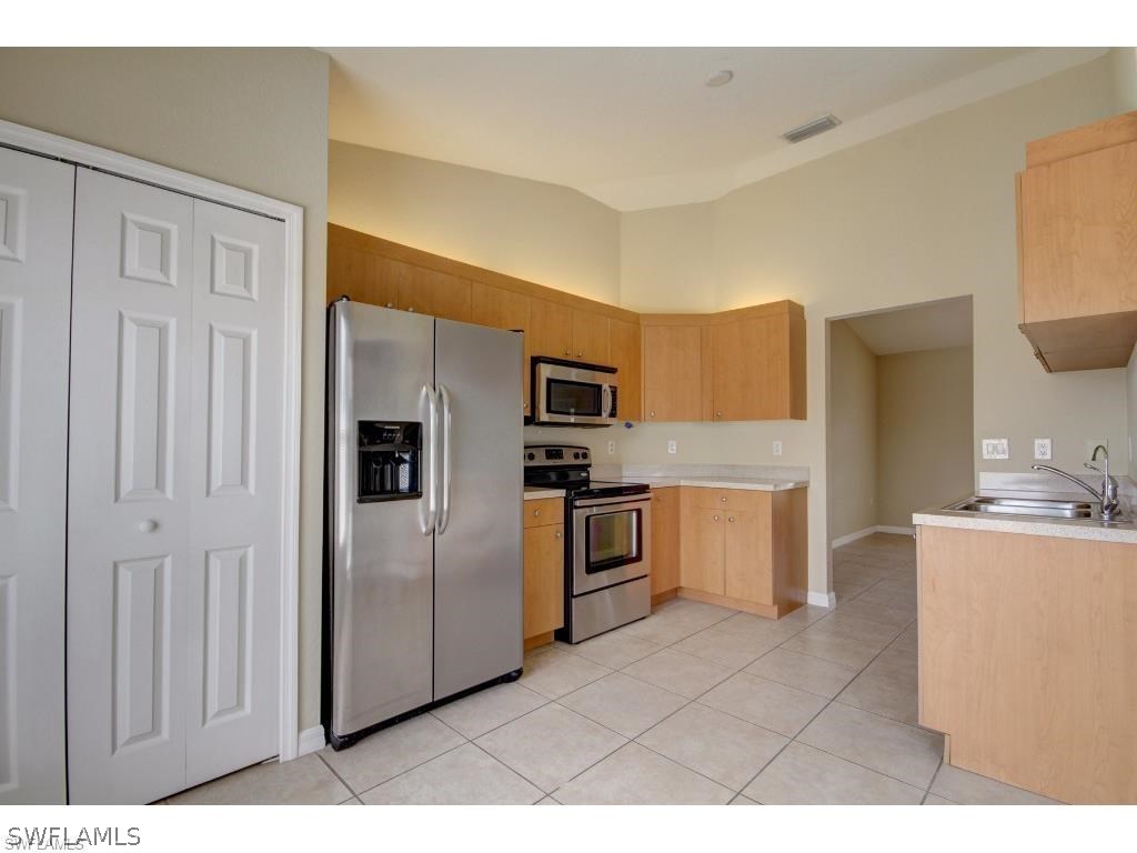 101 West 12th Street Lehigh Acres, FL 33972 - Photo 2 of 7 a kitchen with stainless steel appliances granite countertop a refrigerator and a stove
