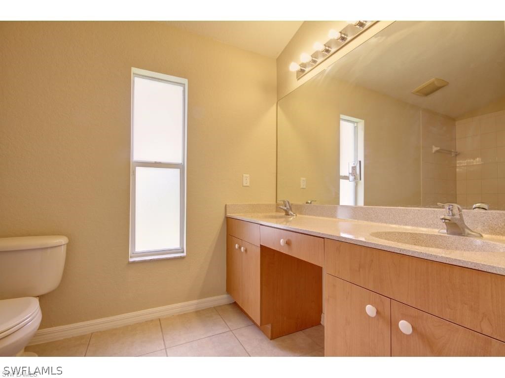 101 West 12th Street Lehigh Acres, FL 33972 - Photo 4 of 7 a bathroom with a toilet sink and mirror
