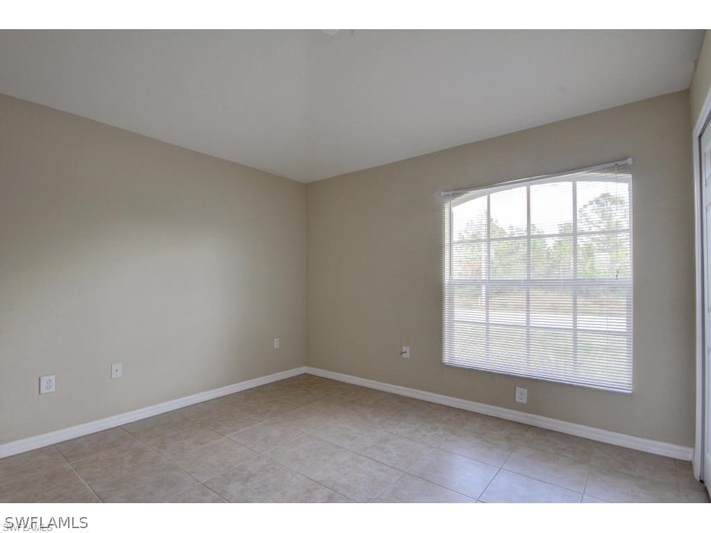 101 West 12th Street Lehigh Acres, FL 33972 - Photo 5 of 7 an empty room with wooden floor and windows