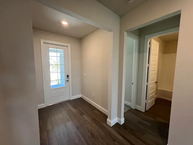 an empty room with wooden floor and a window