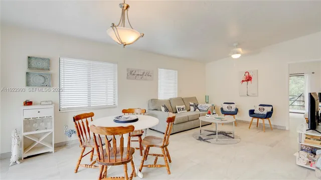a living room with furniture a chandelier and a window
